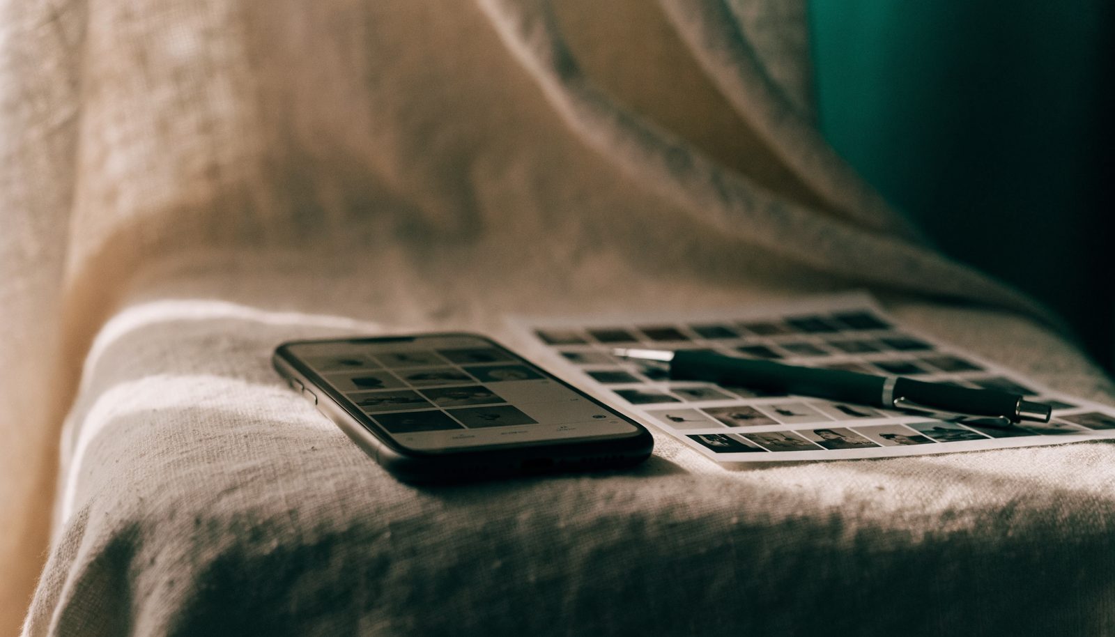 A photography website preview open on a phone beside a contact sheet
